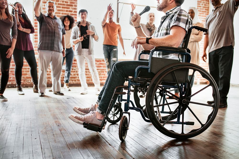 Handicapped man speaking on a microphone in a workshop