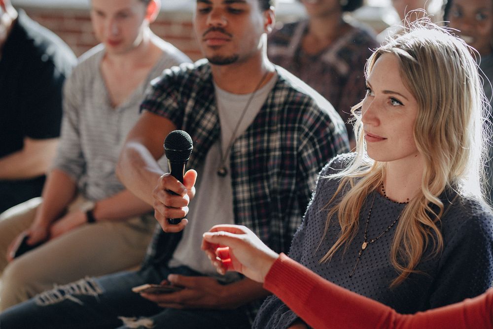 Man handing a microphone to a woman