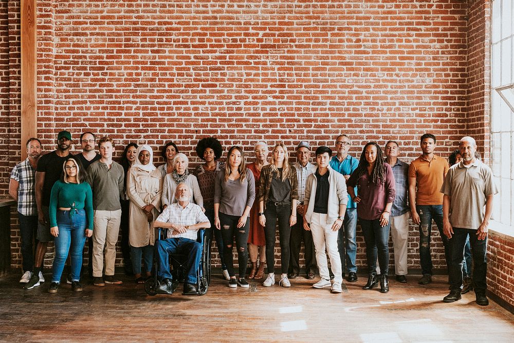 Group of diverse people standing in front of a brick wall