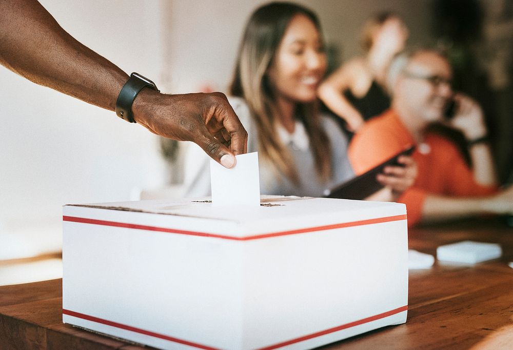 Black man casting his vote to a ballot box