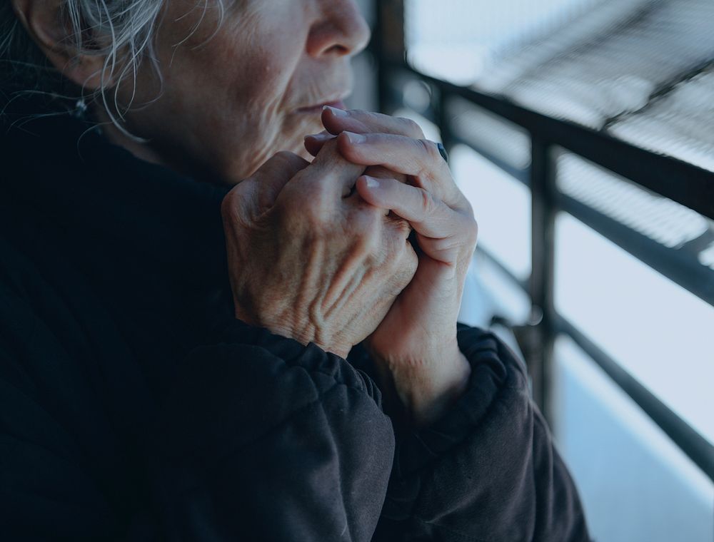 Old woman warming up herself in a cold winter day