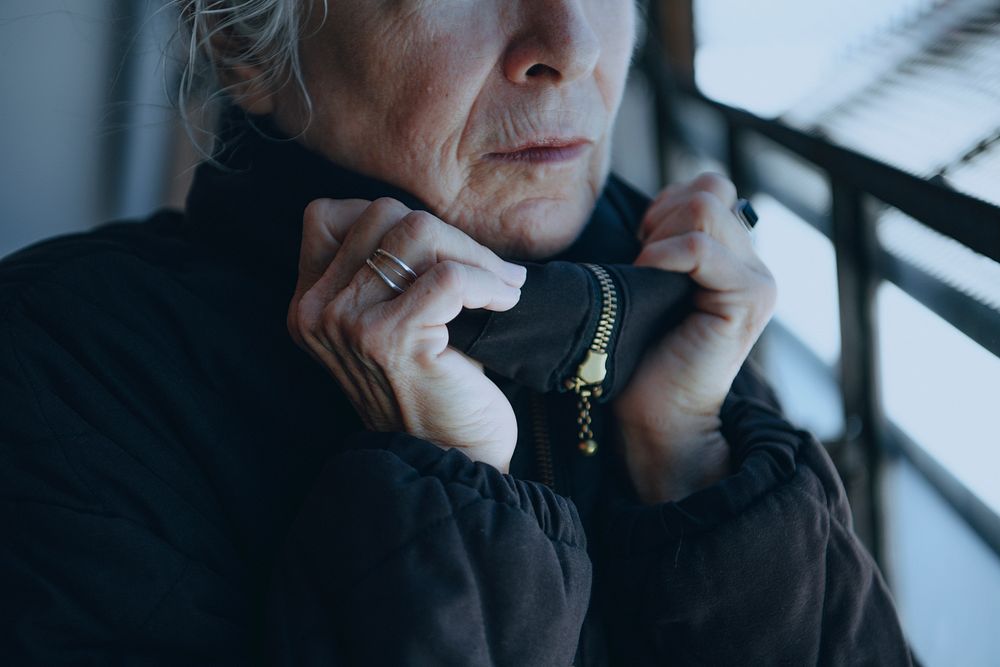 Old woman warming up herself in a cold winter day