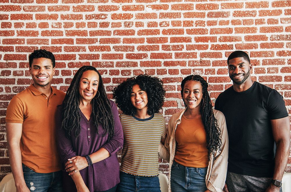 Cheerful black people standing in front of a red brick wall
