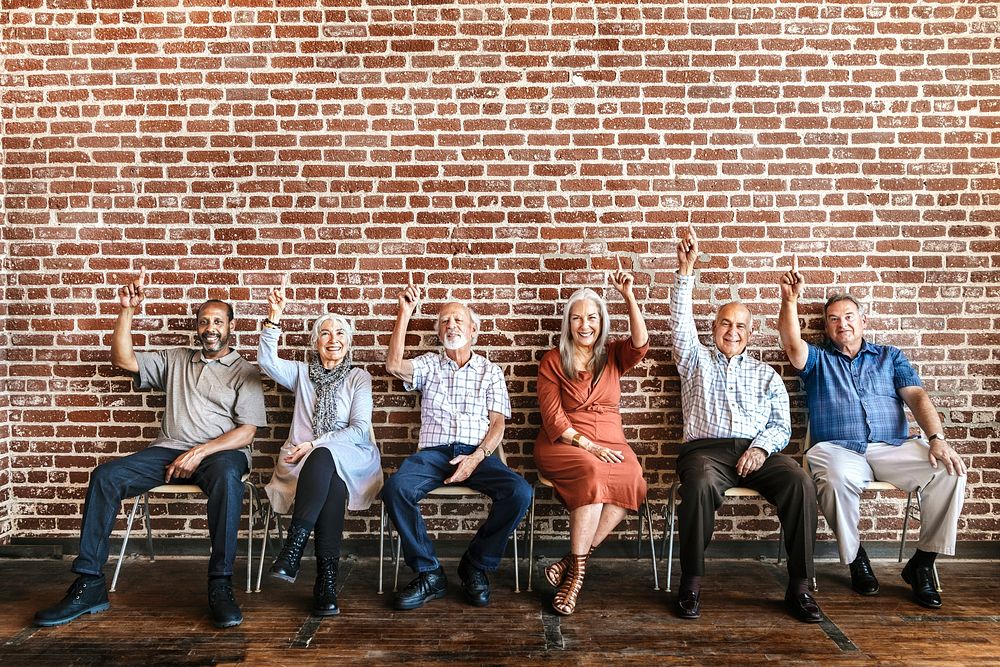 Diverse old people pointing index fingers up 