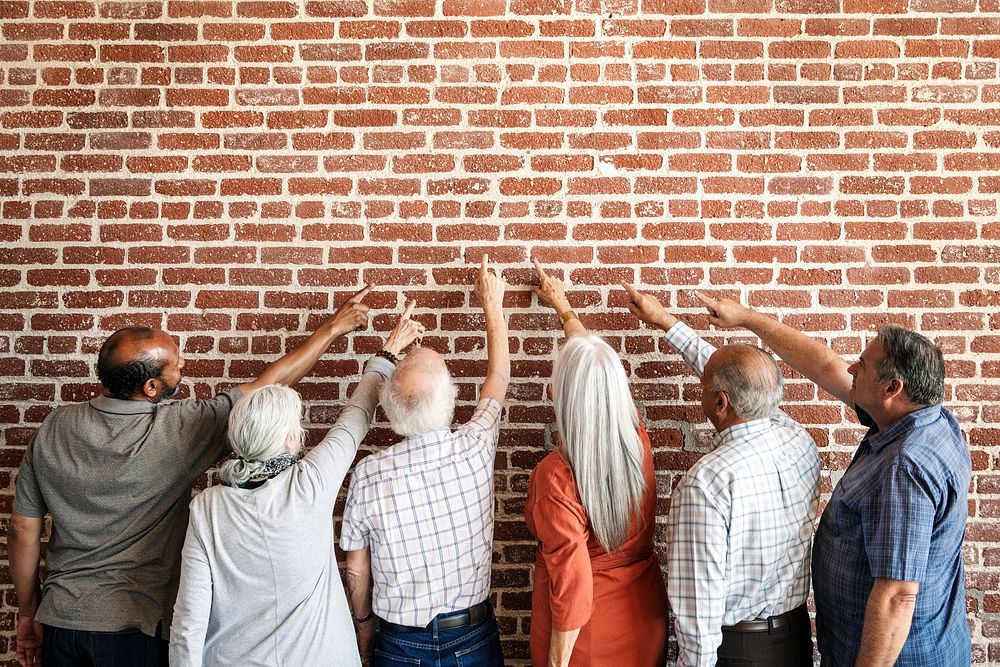 Rear view of elderly people pointing to the wall