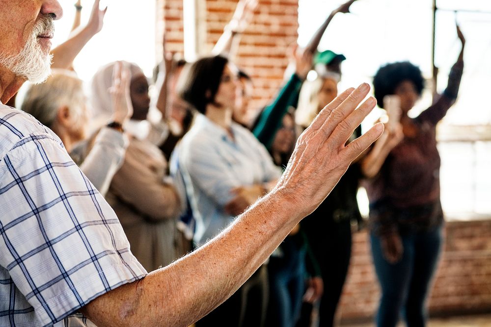 People raising their hands in a seminar