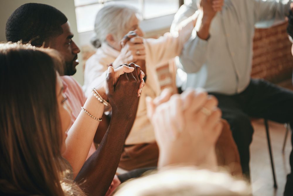 Group of diverse people holding hands up in the air