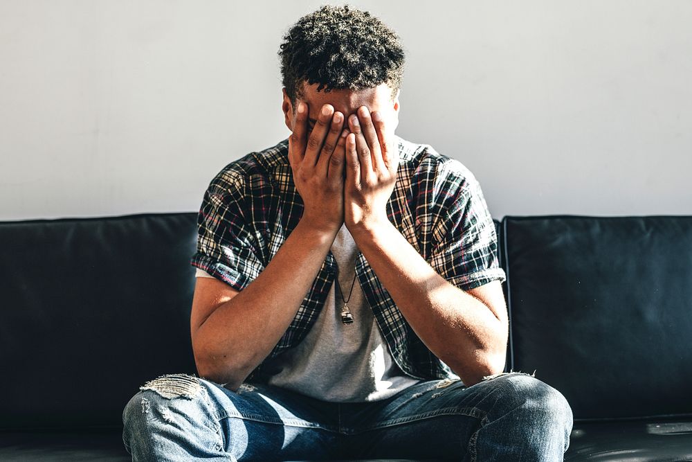 Depressed man sitting alone on a couch