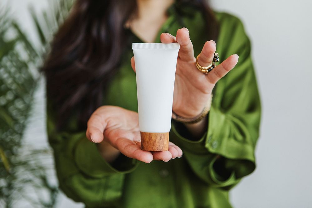 Woman holding lotion with both hands