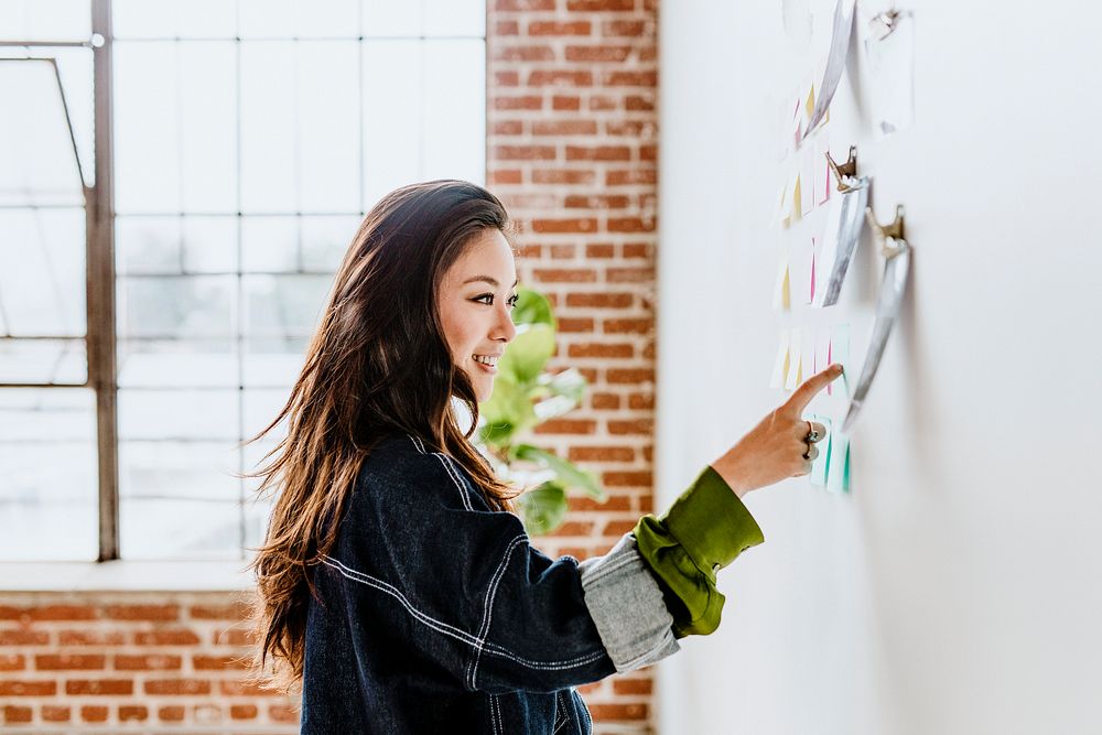 Creative woman with business plans on the wall