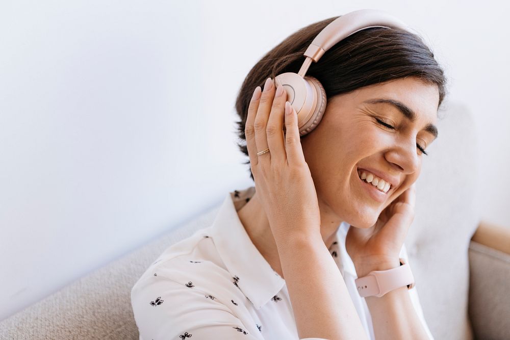 Happy woman with headphones on the couch