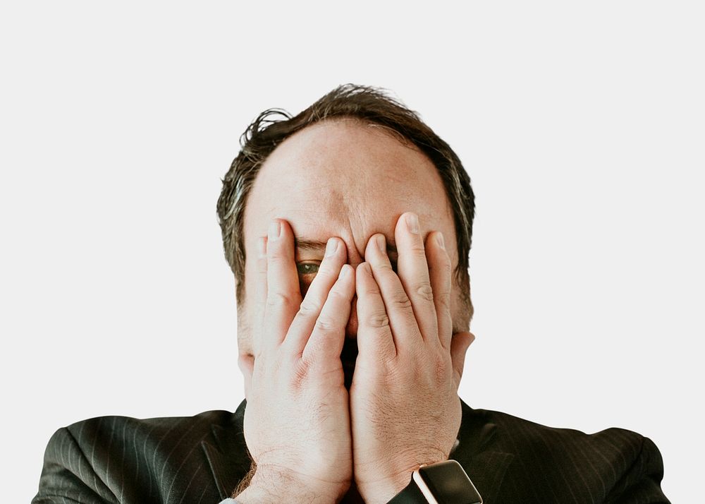 Businessman covering face with hands psd