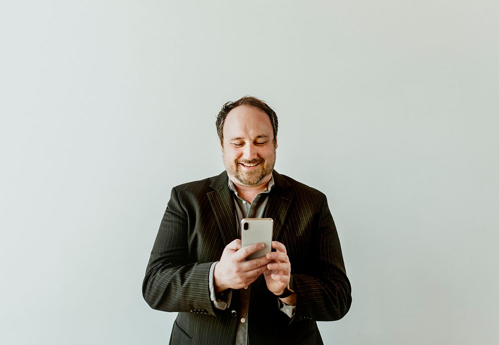 Cheerful man using his phone