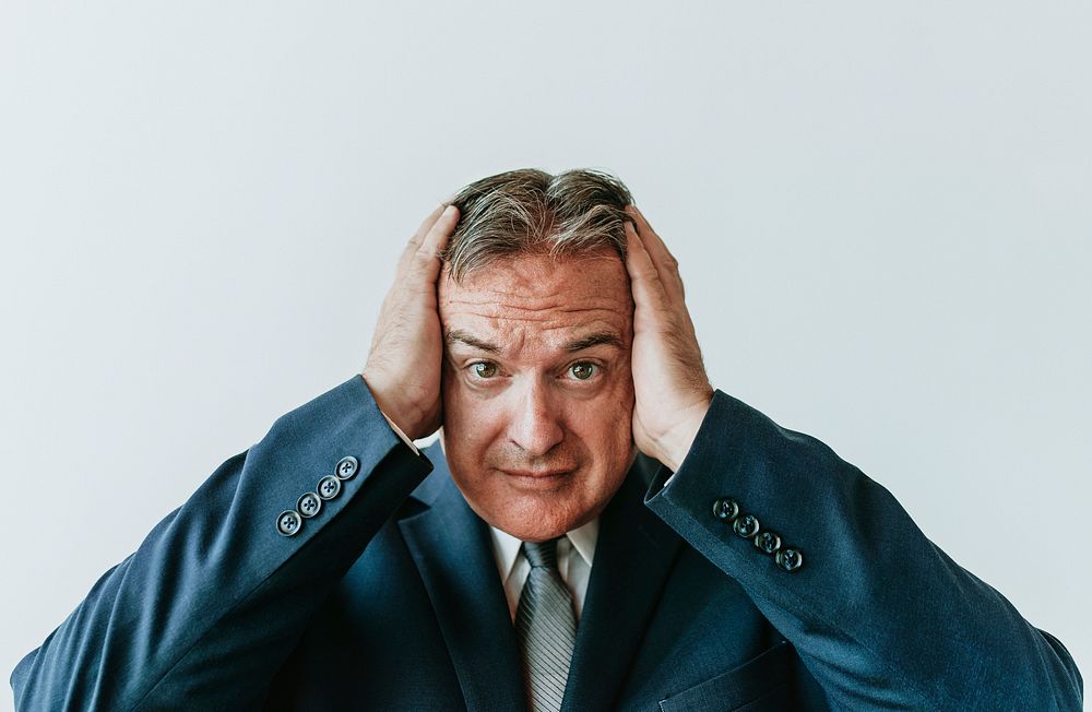 Stressed aged businessman touching his head