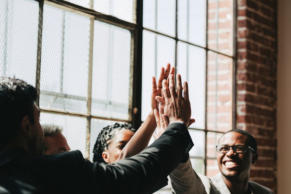 Diverse business people giving a high five in the middle