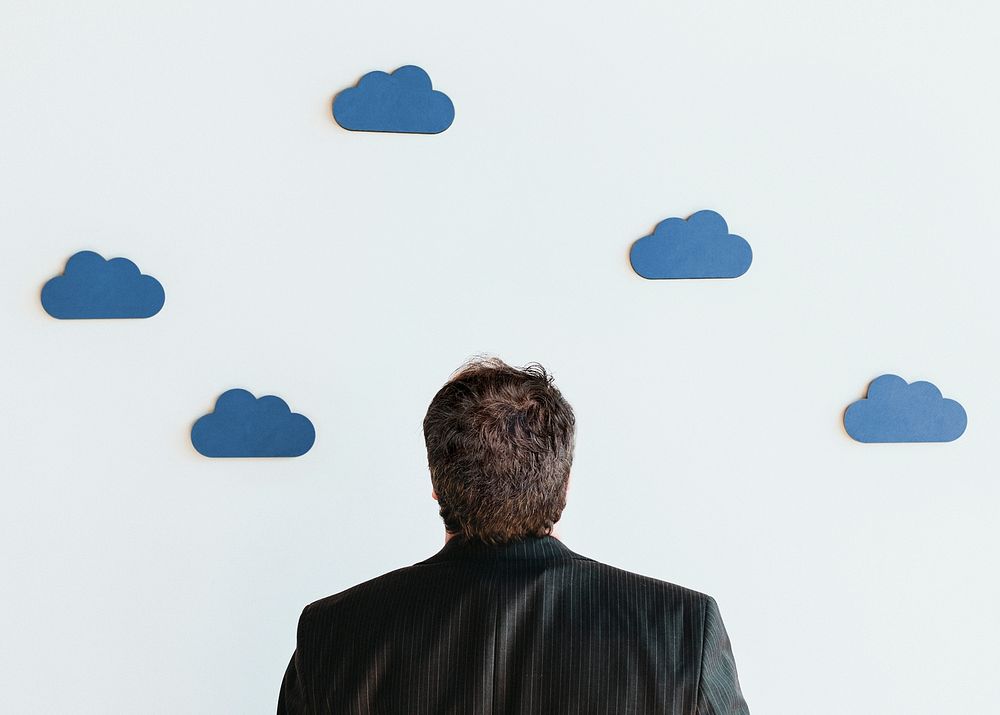 Man looking up to blue cloud icons mockup
