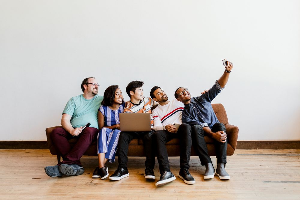 Group of diverse friends taking a selfie on a couch