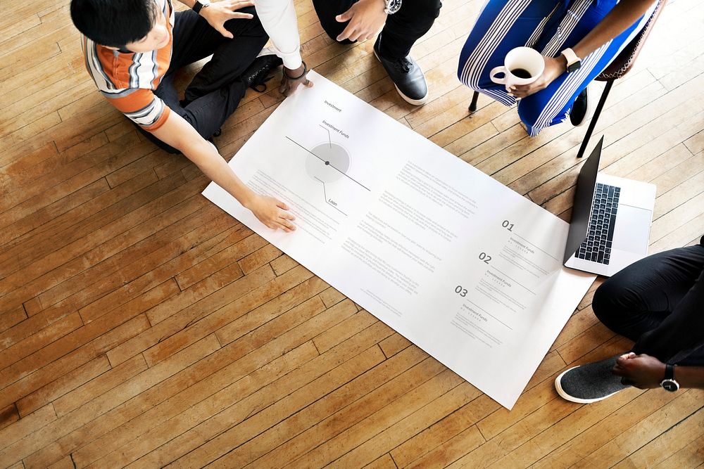 Diverse people brainstorming in a workshop on a paper mockup