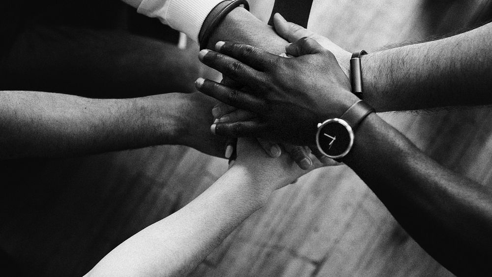 Diverse people joining hands in the middle