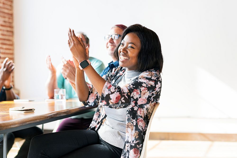 Cheerful woman clapping hands in a meeting