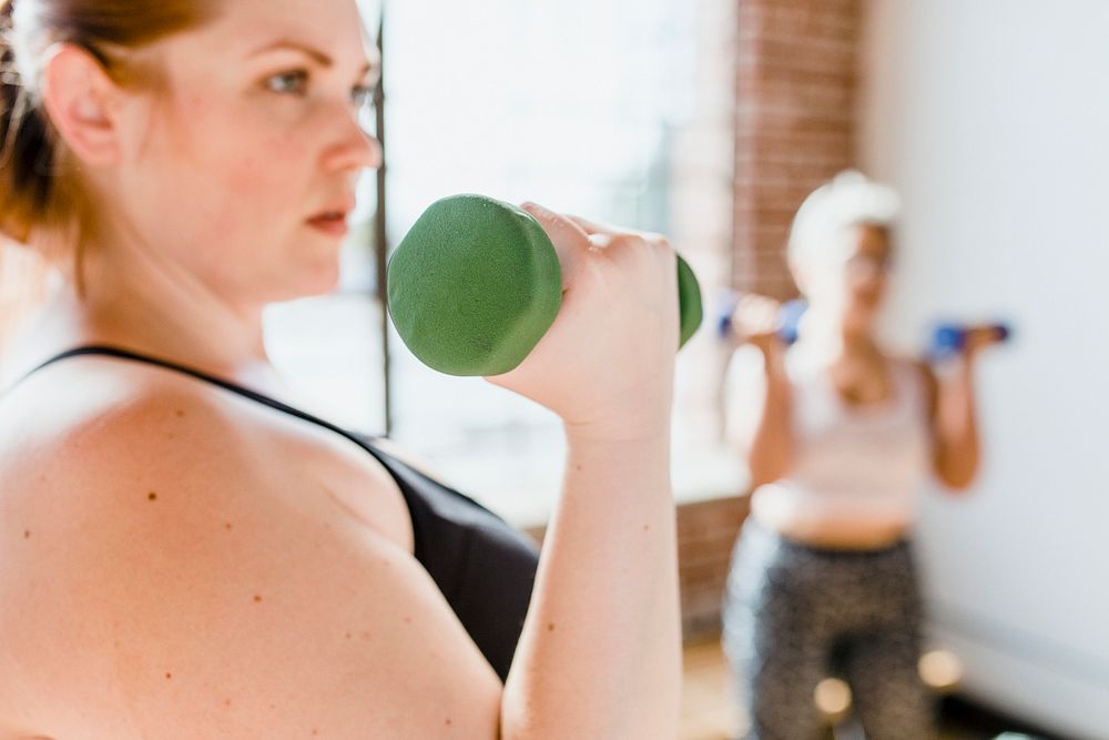 Sporty woman using a dumbbell