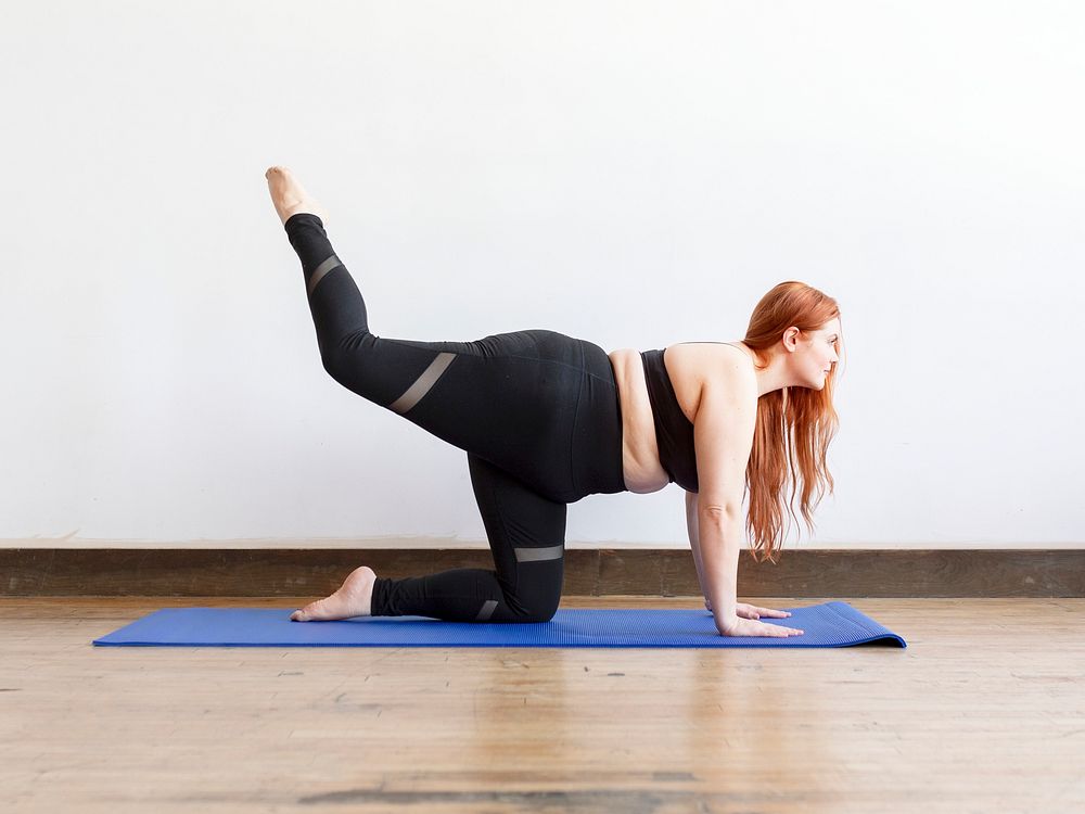 Sporty woman stretching on a yoga mat