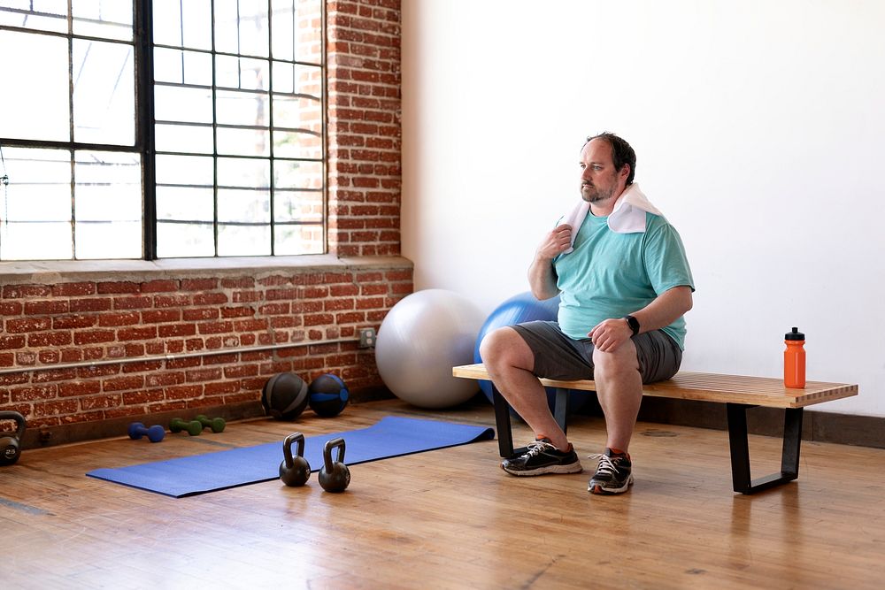 Man sitting on a wooden bench at the gym