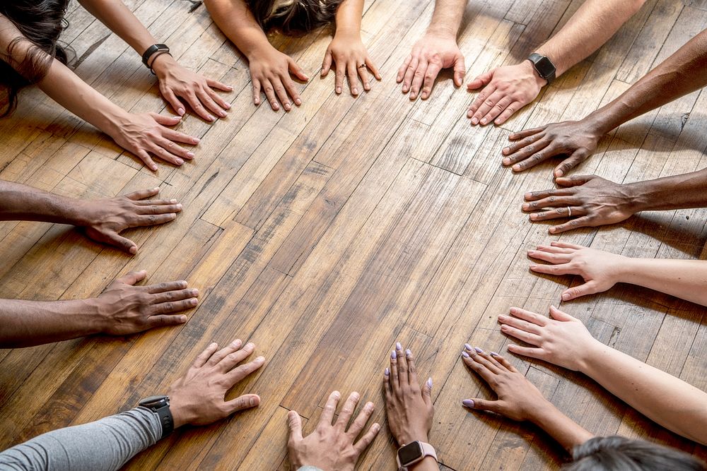 Diverse hands forming a circle on the floor