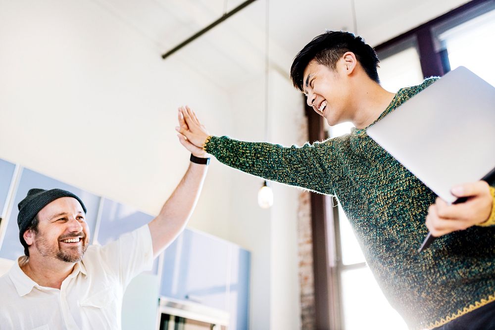 Happy diverse colleagues in a startup company doing a high five