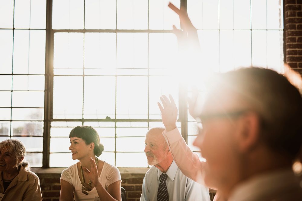 People raised their hand in a meeting