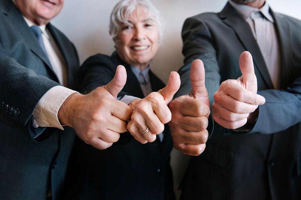 Businesspeople doing a thumbs up together