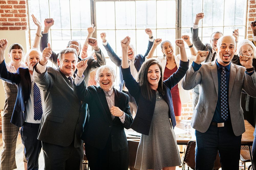 Cheerful businesspeople raising hands in the air