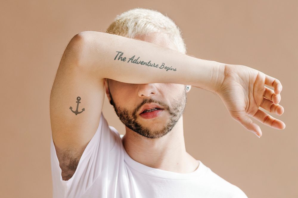 Blond man with tattoos on his arm