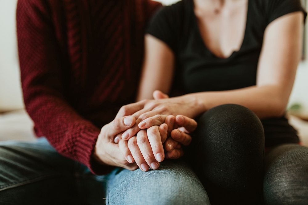 Passionate couple holding hands in bed