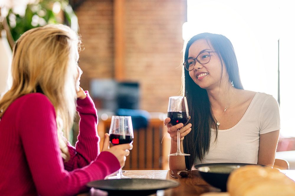 Female friends having red wine at a dinner party