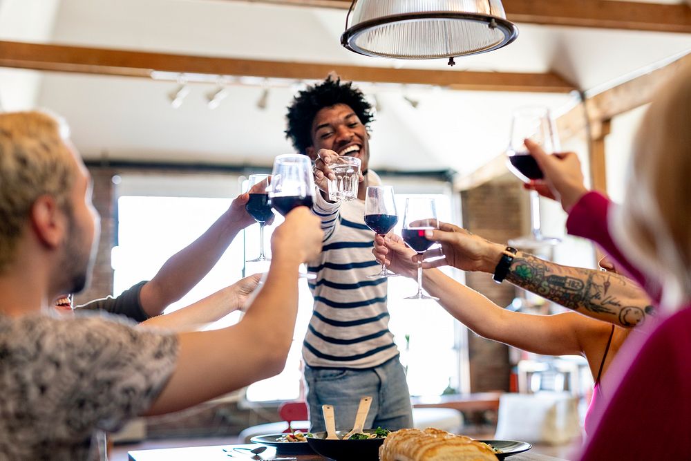 Friends celebrating with red wine at a house party