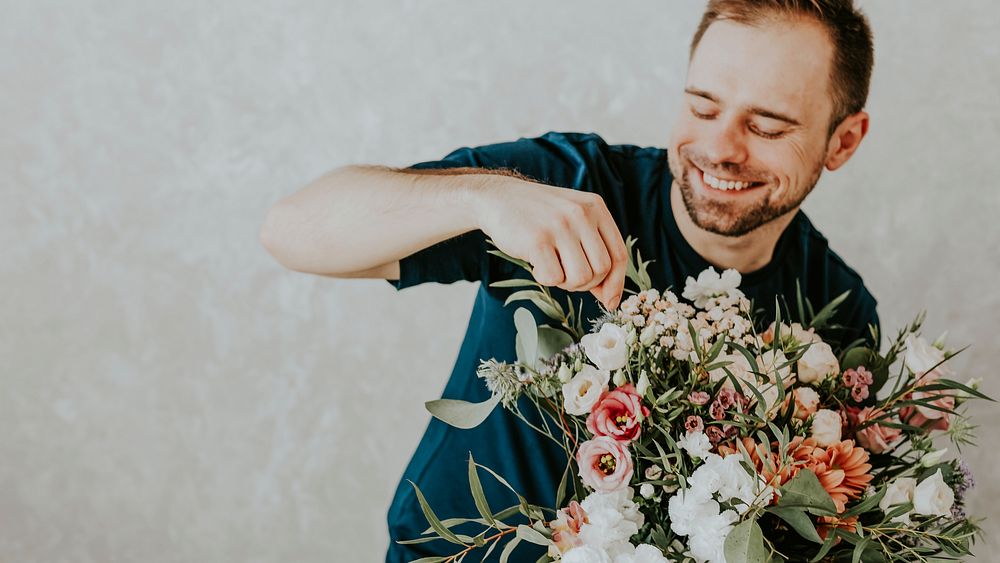 Happy man rearranging the bouquet of flowers