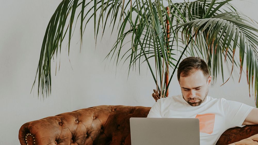 Man on the couch working on his laptop