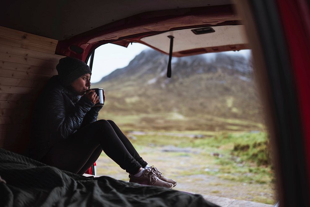 Woman in a camper sipping coffee