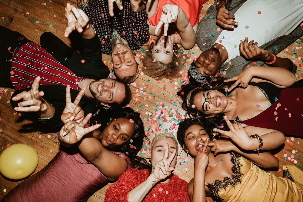 Friends lying on the floor at a party with balloons 