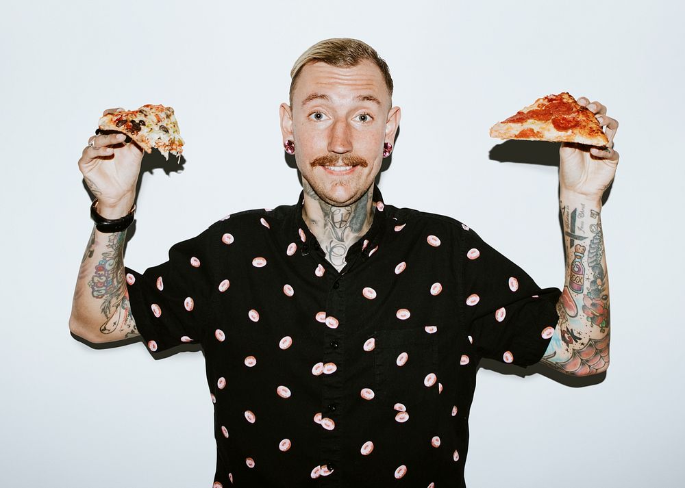 Tattooed man holding a pizza in his hands