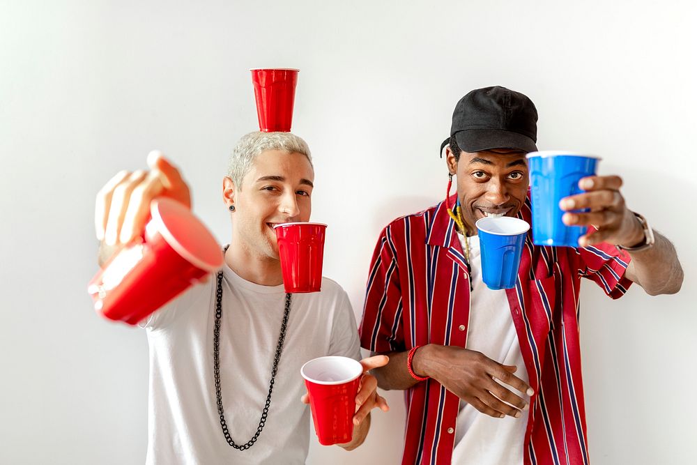 Cheerful young men holding cups
