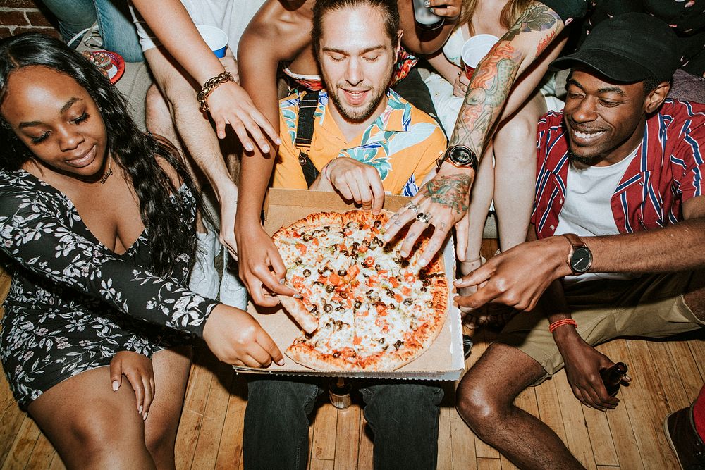 Group of diverse friends enjoying pizza at a party