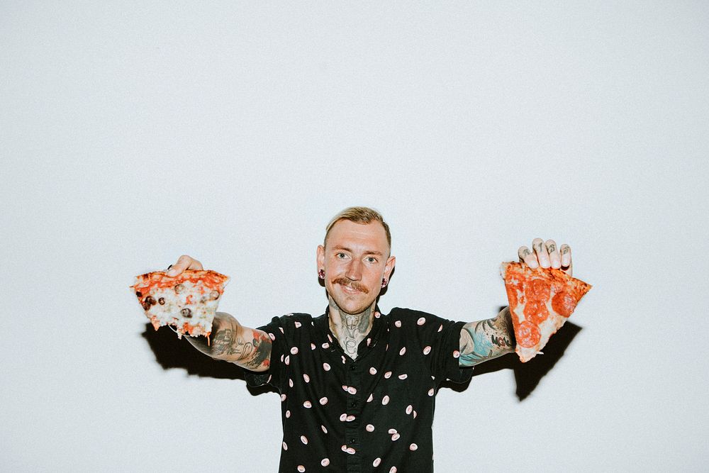 Tattooed man having pepperoni pizza