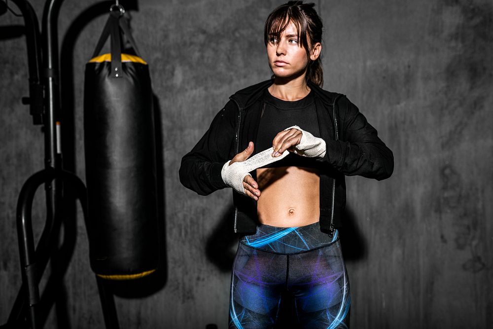 Female boxer putting a strap on her hand