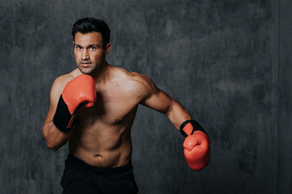 Muscular male boxer with the red boxing gloves