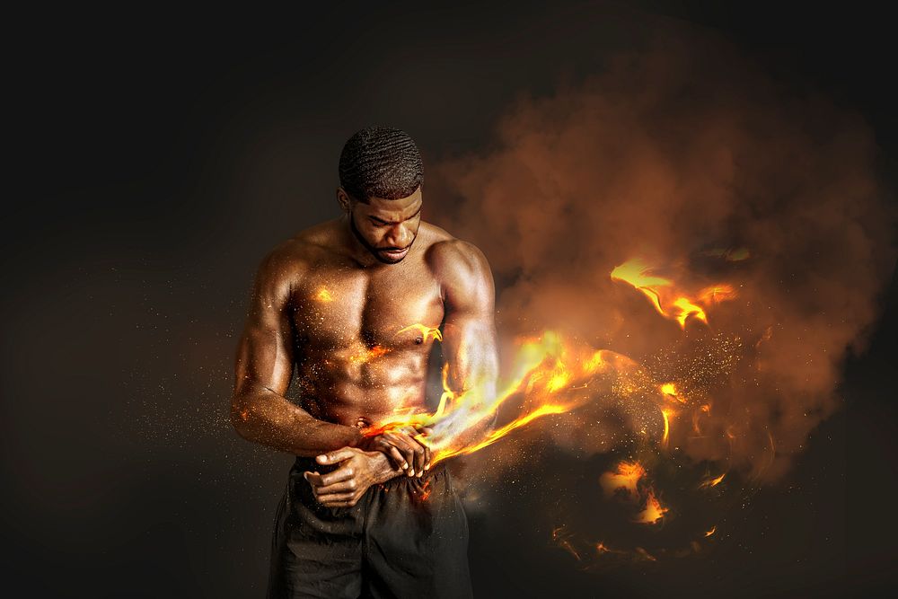 Portrait of a sportive muscular topless man with fire on his arm