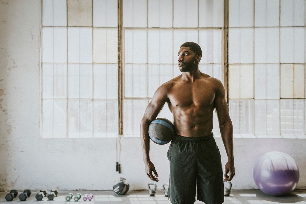 Shirtless muscular man holding a fitness ball