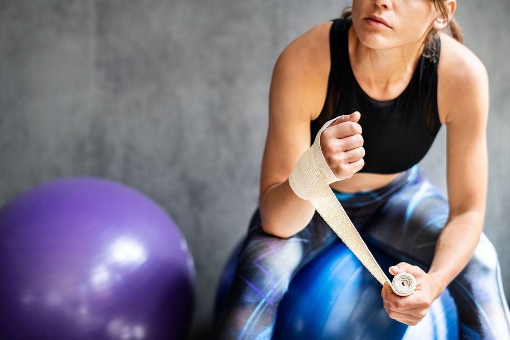 Female boxer putting a strap on her hand