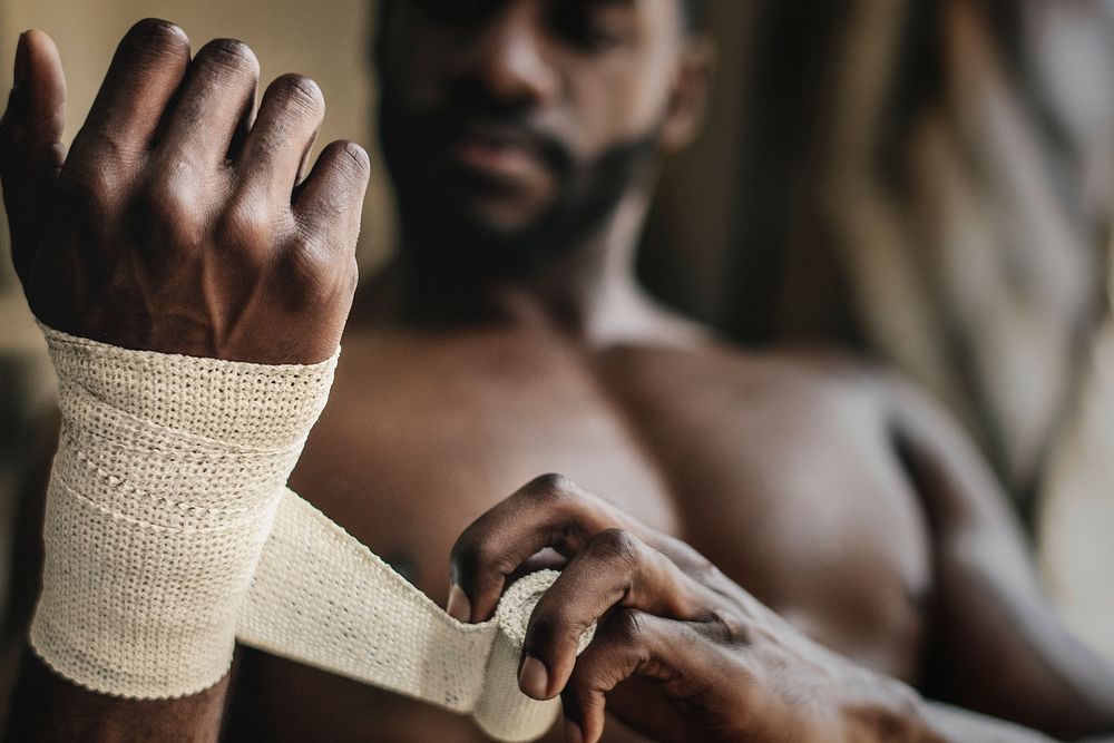 Male boxer putting a strap on his hand